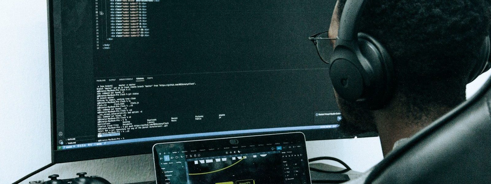 A man sitting in front of a computer wearing headphones