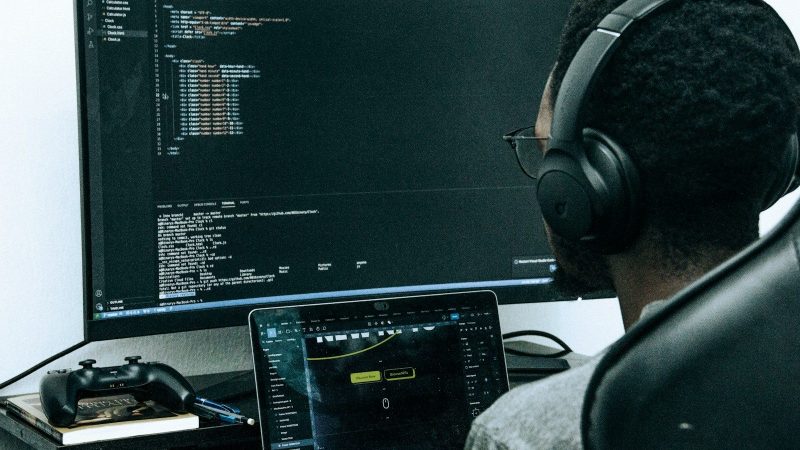 A man sitting in front of a computer wearing headphones