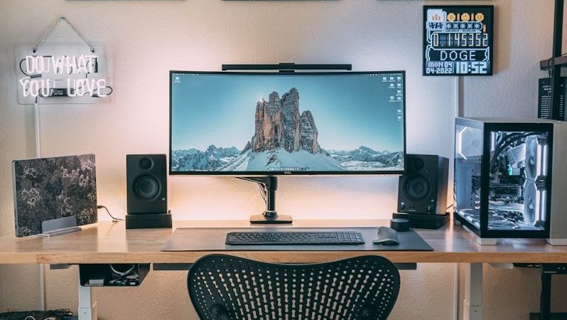 a desk with a computer and speakers on it