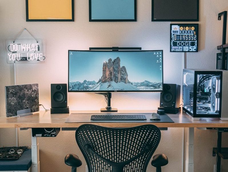 a desk with a computer and speakers on it